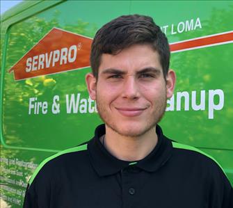 Young man standing in front of green van